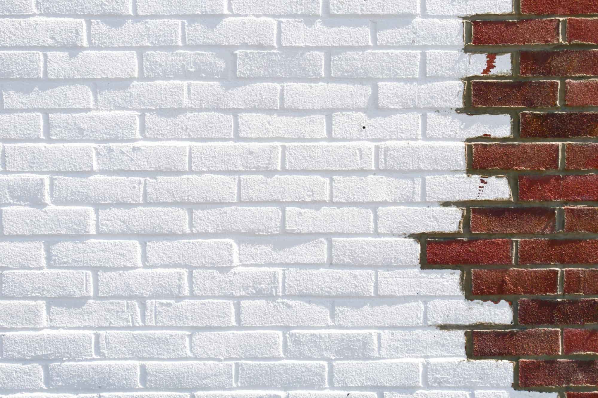 Brick wall partially covered with white paint