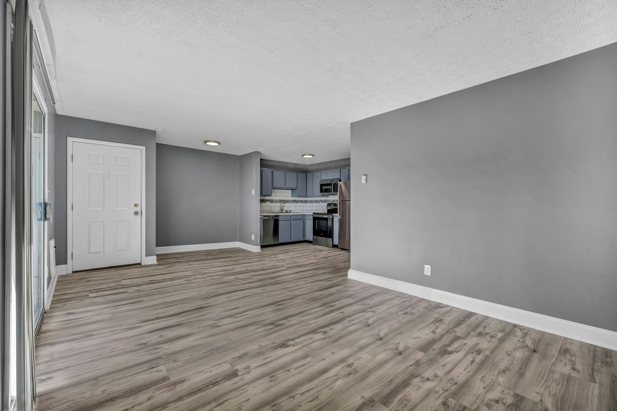 Empty room with gray walls and wood-look plank flooring
