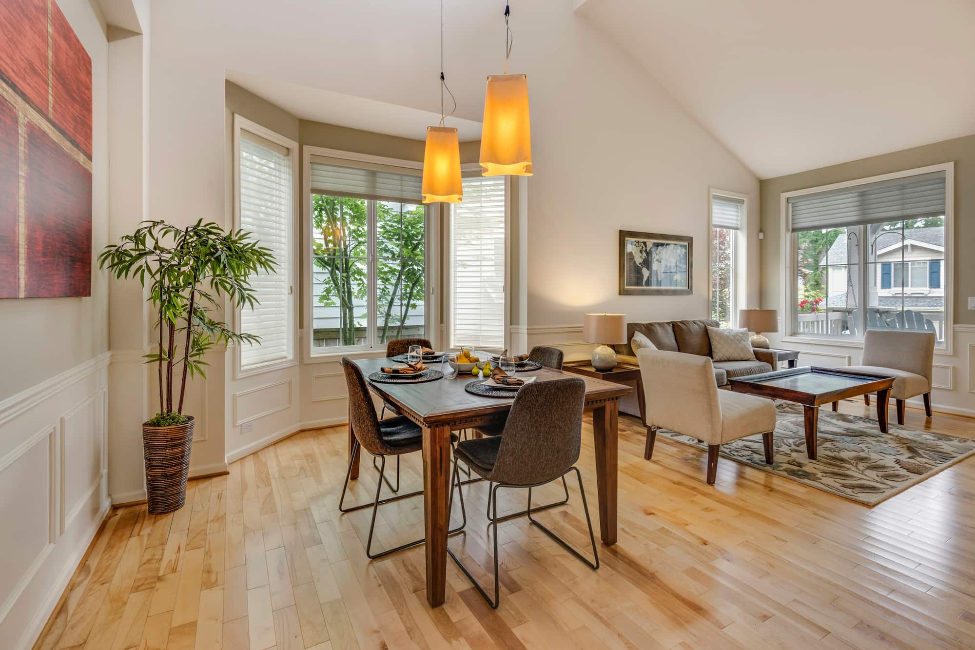 Open living and dining area with pendant lights and wooden flooring