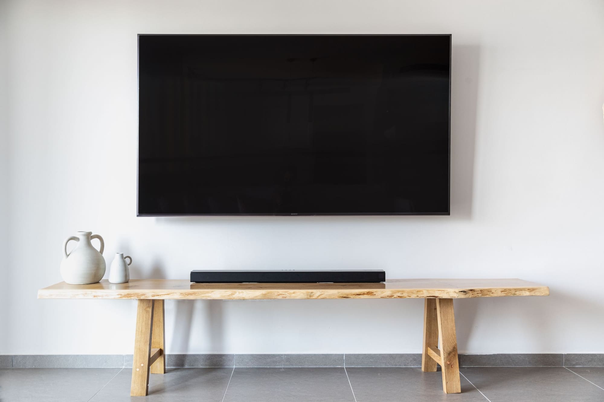 Wall-mounted television above a console table